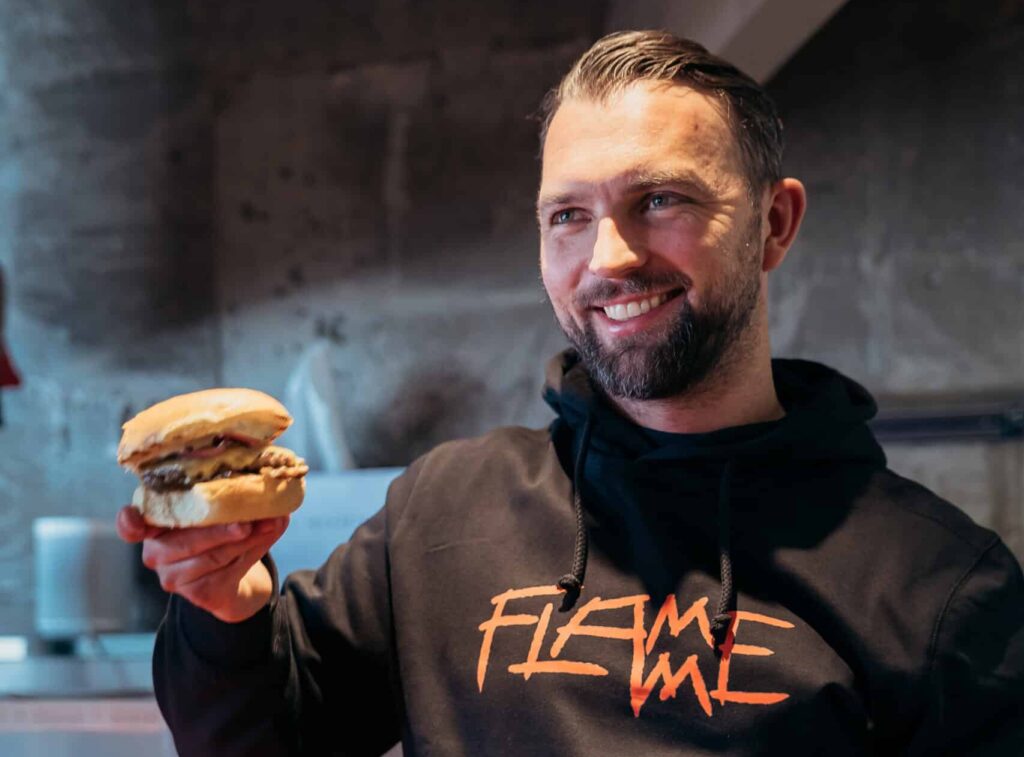 Mesterkokk Øyvind Bøe Dalelv viser smilende og stolt frem en hjemmelaget burger i verdensklasse.